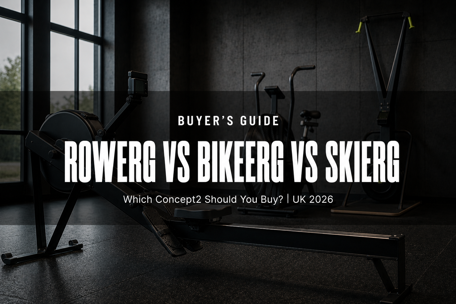 An indoor rowing machine, an air bike and a wall-mounted ski trainer on dark rubber flooring in a modern UK gym