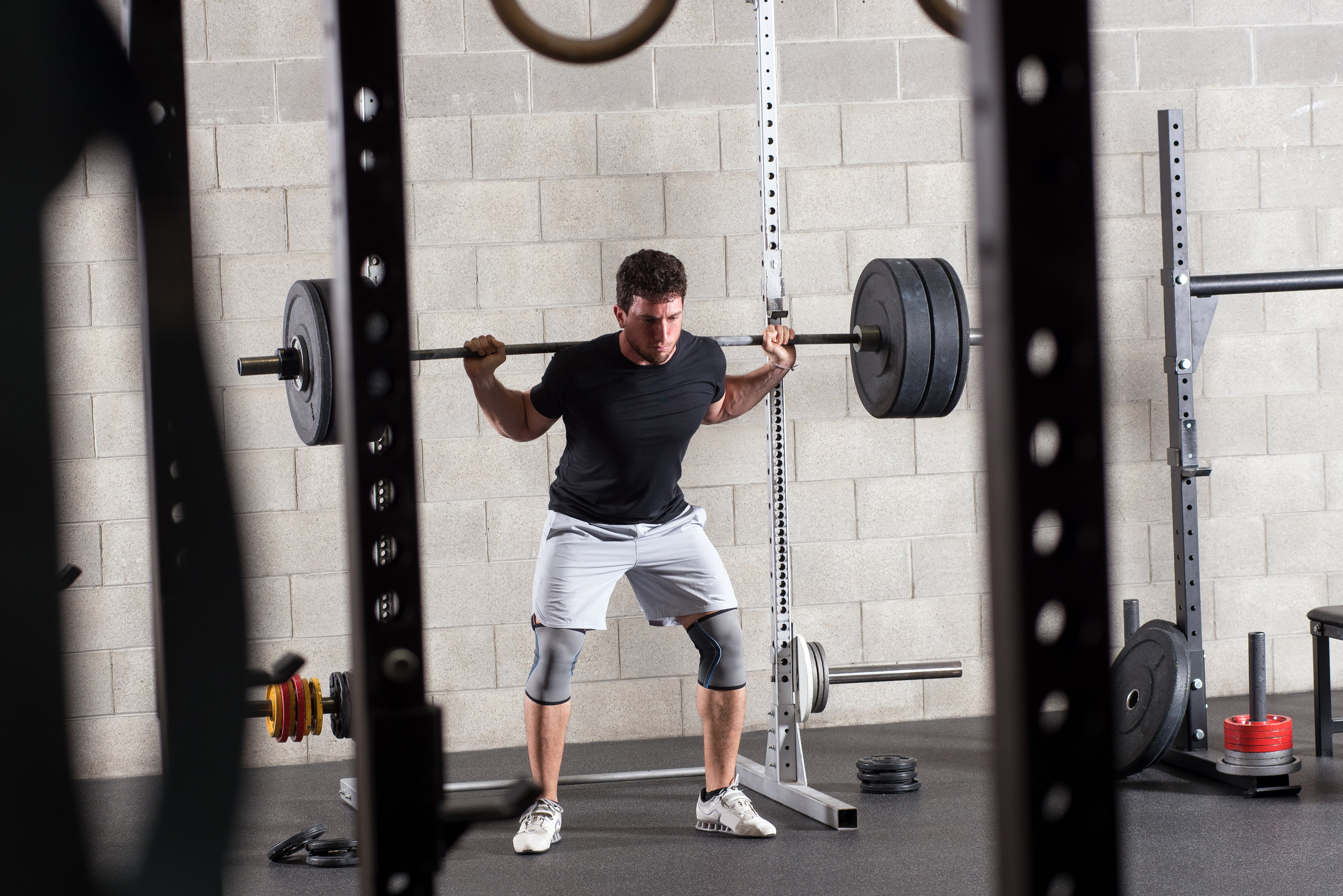 man squatting in the gym 