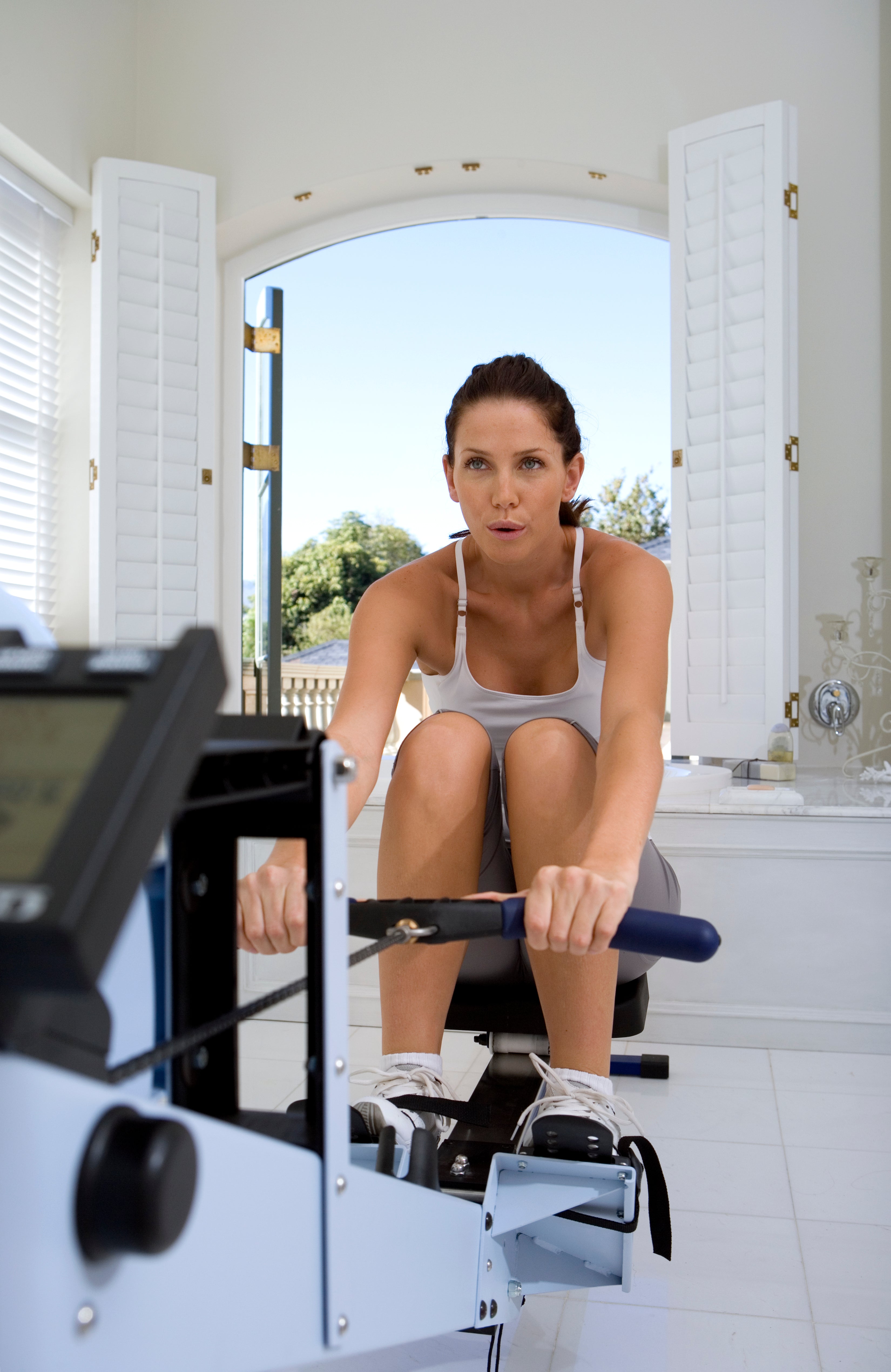women dressed in white on rowing machine