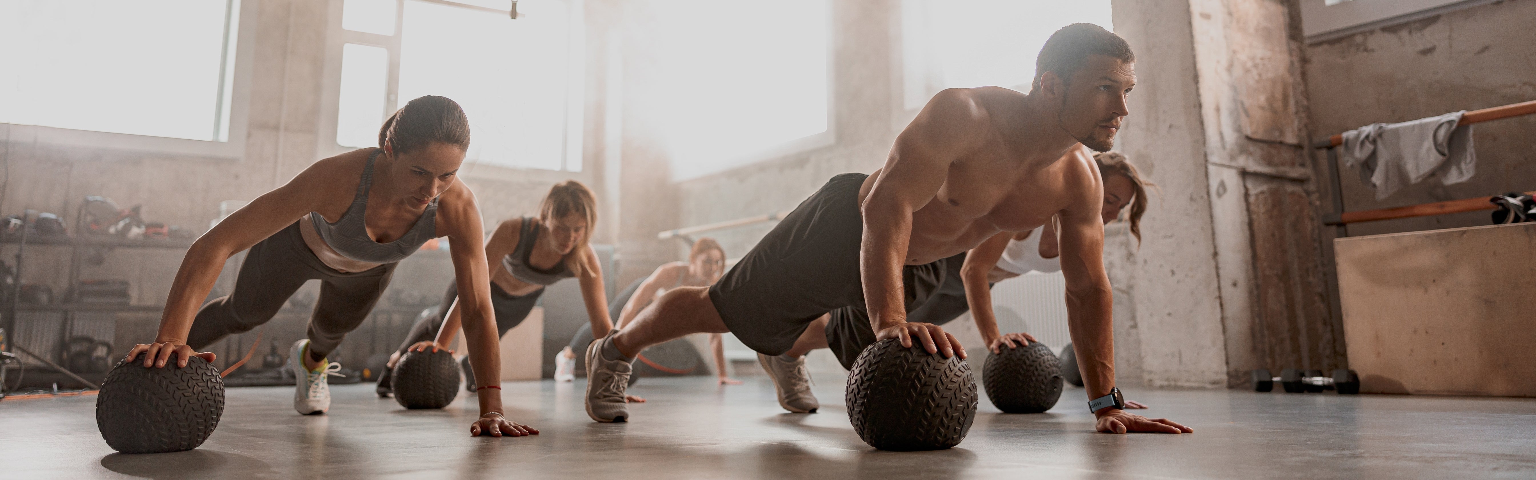 People doing press ups with medicine ball