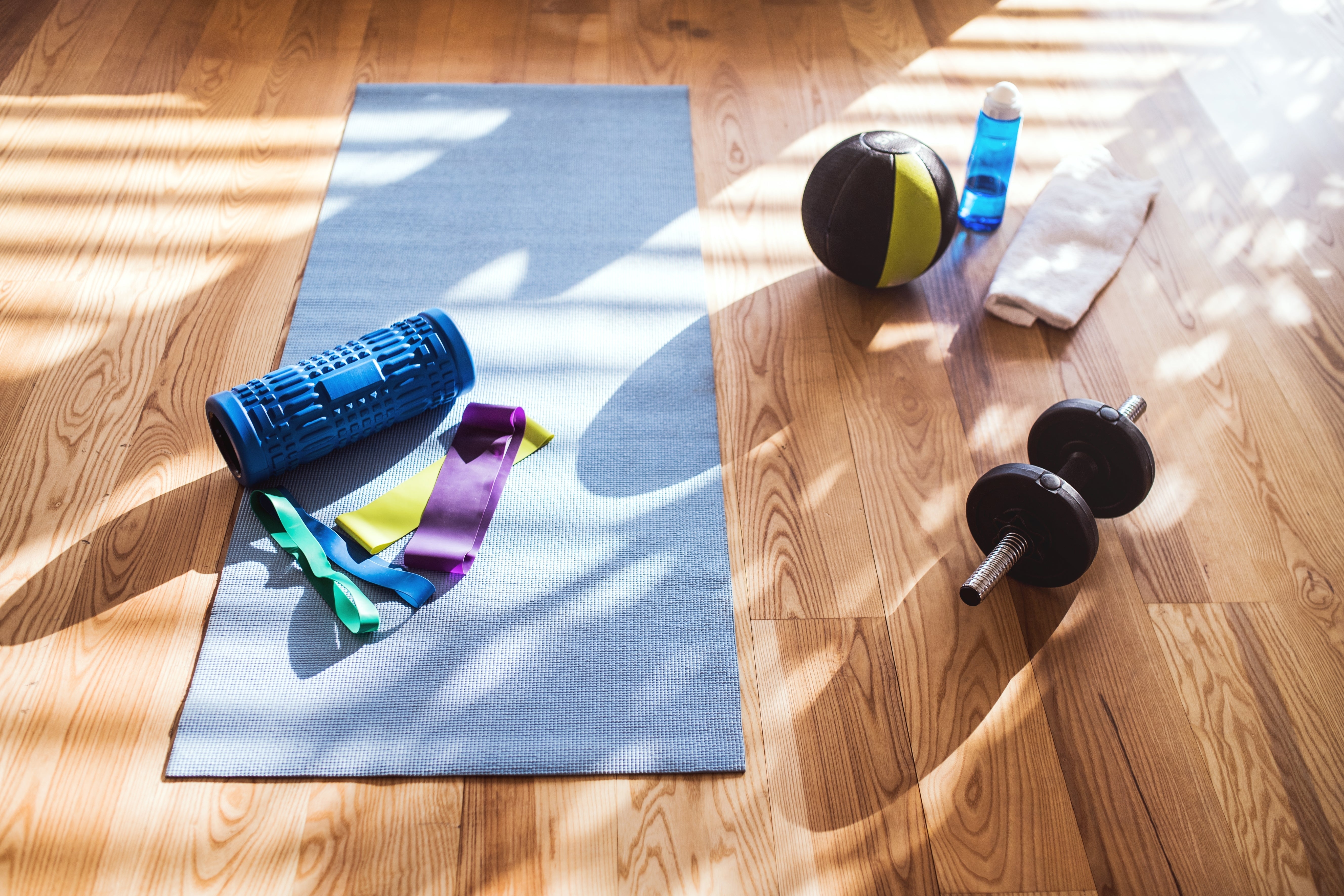 Fitness accessories and yoga mat on a wooden floor